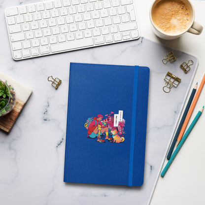 A blue notebook with an illustration of a hiker with a prosthetic leg and a dog, set against Japanese shops, lies on a marble desk.