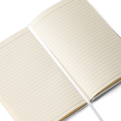 An open notebook displaying lined cream-colored pages with a white ribbon bookmark running down the center.